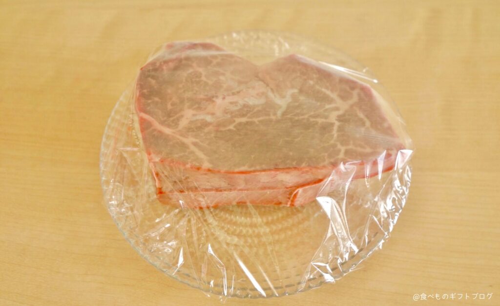 お皿に乗った石井精肉店「ヒレテートステーキ」にラップをかけている
